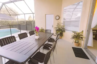 a dining room with a table and chairs and a pool at Spacious Home Perfect for Big Families in Kissimmee