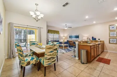 a kitchen and living room with a table and chairs at 4Q/ Paradise Palms com Piscina Privativa in Kissimmee