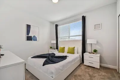a white bedroom with a bed and a window at Storey Lake * Linda Casa 5 quartos com sala de jogos in Kissimmee