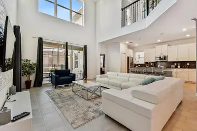 a living room with a white couch and a table at Storey Lake * Linda Casa 5 quartos com sala de jogos in Kissimmee