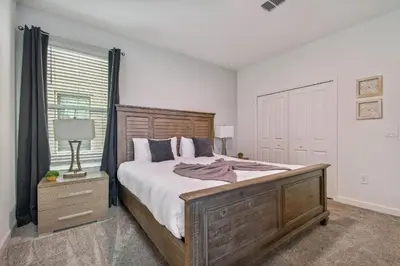 a bedroom with a large bed and a window at Storey Lake * Linda Casa 5 quartos com sala de jogos in Kissimmee