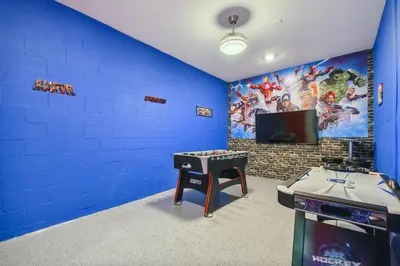 a blue room with a table and a tv at Storey Lake * Linda Casa 5 quartos com sala de jogos in Kissimmee