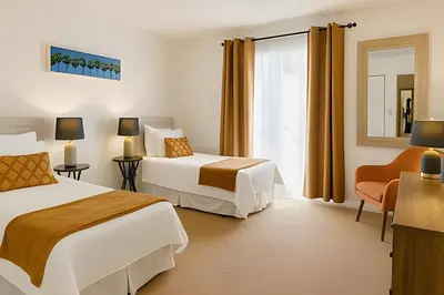 a hotel room with two beds and a chair at Casa 3 Quartos c/ Piscina perto da Disney! in Kissimmee