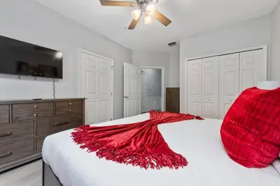 a bedroom with a bed with a red blanket on it at Casa 3Q no Vista Cay- Perto da Universal in Orlando
