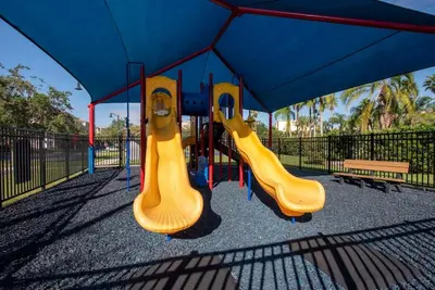 two slides on a playground with a blue roof at Casa 3Q no Vista Cay- Perto da Universal in Orlando