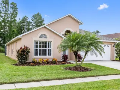 a pink house with a palm tree in front of it at Holiday Home Ferienvilla mit Garten- Grill und Terrasse by Interhome in Orlando