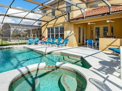 a swimming pool with blue chairs and a house at Holiday Home Bella Vida Resort Pool und Spa Rückzugsort by Interhome in Kissimmee
