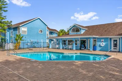 a blue house with a swimming pool in front of it at Resort Stay Near Disney Bright Gym Hot Tub in Kissimmee