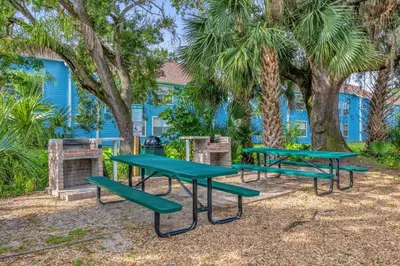 a group of picnic tables in front of a blue building at Resort Stay Near Disney Bright Gym Hot Tub in Kissimmee