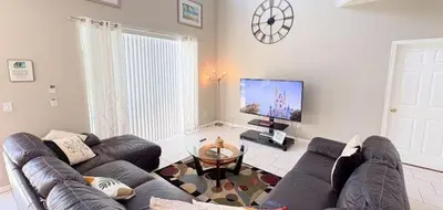 a living room with a couch and a tv at 648 - Spacious 6-Bedroom Emerald Island Retreat with Pool, Spa & Games Room Near Disney in Kissimmee