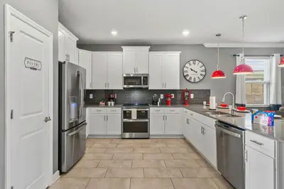 a kitchen with white cabinets and a clock on the wall at 4177 Paragraph Drive in Kissimmee