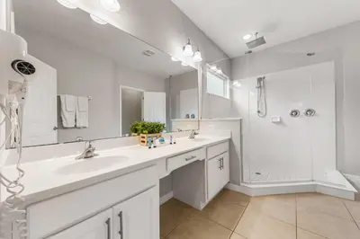 a white bathroom with a sink and a shower at 4449 Shiva Loop in Kissimmee
