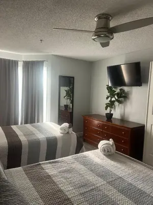 a bedroom with two beds and a dresser and a tv at Condo Universal Disney Epic Free Parking in Orlando