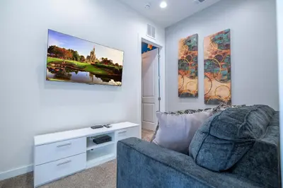 a living room with a couch and paintings on the wall at Townhome 3Q no Summerville com Quarto Temático in Orlando