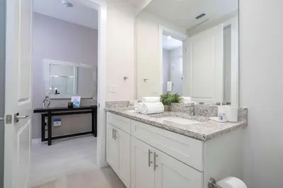 a bathroom with a sink and a large mirror at Townhome 3Q no Summerville com Quarto Temático in Orlando