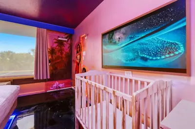 a pink room with a large tv on the wall at Moana Adventure Suite Near Disney in Kissimmee
