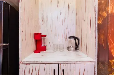 a wooden cabinet with a blender and glasses on it at Moana Adventure Suite Near Disney in Kissimmee