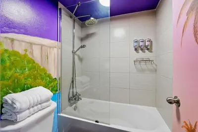 a bathroom with a shower and a tub and a sink at Moana Adventure Suite Near Disney in Kissimmee