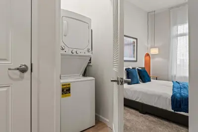 a bedroom with a bed and a mirror on the door at Riviere Apartments King Bed Suite & Pool & Gym & Pet Friendly & Near Epic Universe in Orlando