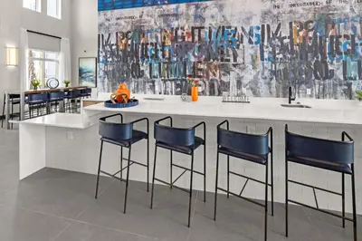 a kitchen with a bar with four blue chairs at Riviere Apartments King Bed Suite & Pool & Gym & Pet Friendly & Near Epic Universe in Orlando