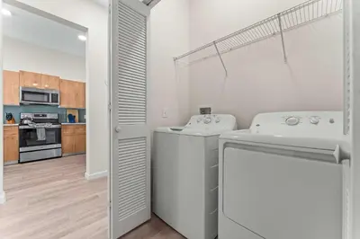 a white laundry room with a washer and dryer at Riviere 2BR Apartment Pet Friendly Oasis Sleeps 6 Close to Epic Universe Pool & Gym in Orlando