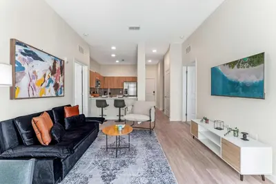 a living room with a couch and a table at Riviere 2BR Apartment Pet Friendly Oasis Sleeps 6 Close to Epic Universe Pool & Gym in Orlando