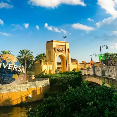 a bridge over a river in front of a building at Riviere 3BR Apartment Stylish King Family Pets Friendly Pool & Gym Near Epic Universe in Orlando