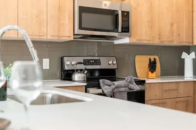 a kitchen with a stove and a microwave and a sink at Riviere 3BR Apartment Stylish King Family Pets Friendly Pool & Gym Near Epic Universe in Orlando