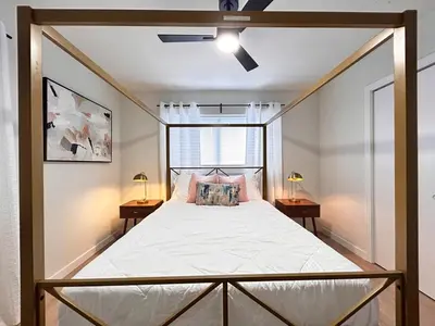 a bedroom with a canopy bed with two tables at Cozy Modern 3BR Escape - Sanford in Sanford