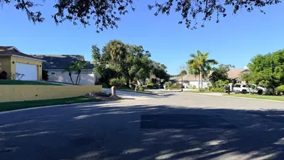 an empty street in a residential neighborhood with palm trees at The little Manatee Apartment in Orlando
