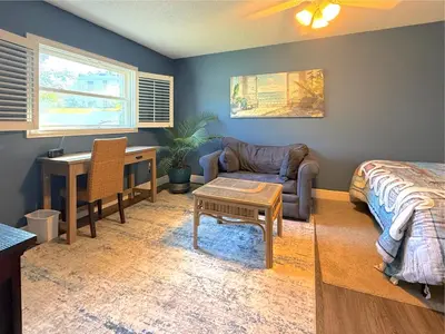 a living room with a bed a desk and a couch at The little Manatee Apartment in Orlando