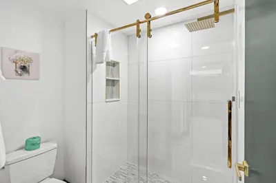 a white bathroom with a glass shower stall at Cozy 1BR near Universal International Drive in Orlando
