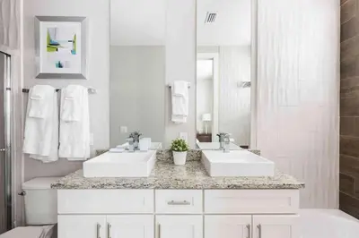 a white bathroom with two sinks and a mirror at Townhome 4Q em Summerville Resort – Orlando in Orlando