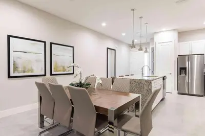 a kitchen and dining room with a wooden table and chairs at Townhome 4Q em Summerville Resort – Orlando in Orlando