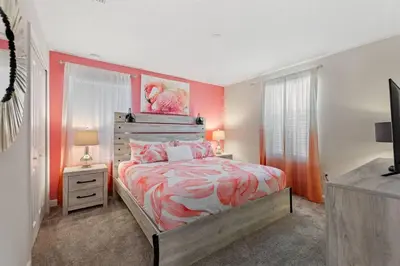 a bedroom with a bed with an orange and white comforter at Bookmark Villa 8Q no Storey Lake c/ Piscina in Kissimmee