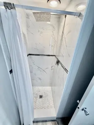 a bathroom with a shower with white marble at Entire condo near Universal Studios in Orlando - Free Resort Access in Orlando