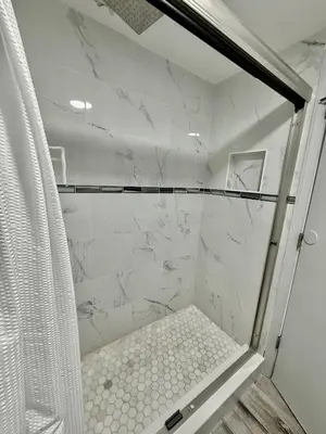 a bathroom with a shower with white marble at Entire condo near Universal Studios in Orlando - Free Resort Access in Orlando