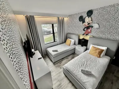 a small bedroom with a mickey mouse mural on the wall at Entire condo near Universal Studios in Orlando - Free Resort Access in Orlando