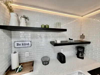 a kitchen with black shelves on the wall at Entire condo near Universal Studios in Orlando - Free Resort Access in Orlando
