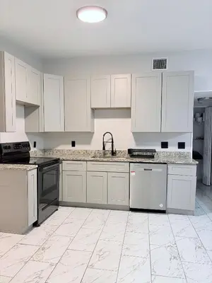 an empty kitchen with white cabinets and appliances at Game Day Getaway-Downtown Orlando in Orlando