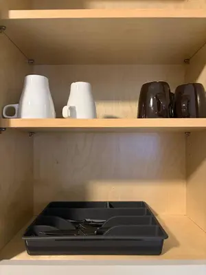 a shelf with cups and a stove in a kitchen at Game Day Getaway-Downtown Orlando in Orlando