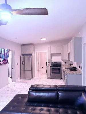a living room with a couch and a kitchen at Game Day Getaway-Downtown Orlando in Orlando