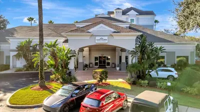 two cars parked in front of a house at FREE Shuttle & 50 Dollars Disney Gift Card Disney Resort Condo in Orlando