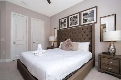 a bedroom with a large white bed with a headboard at Townhome 4Q c/ Temática Disney in Orlando