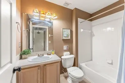 a bathroom with a sink and a toilet and a tub at Casa Familiar 3Q c/ Clubhouse Perto da Disney in Kissimmee