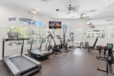 a gym with several treadmills and machines in a room at Casa Familiar 3Q c/ Clubhouse Perto da Disney in Kissimmee