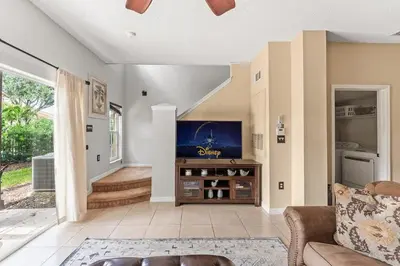 a living room with a couch and a flat screen tv at Casa Familiar 3Q c/ Clubhouse Perto da Disney in Kissimmee