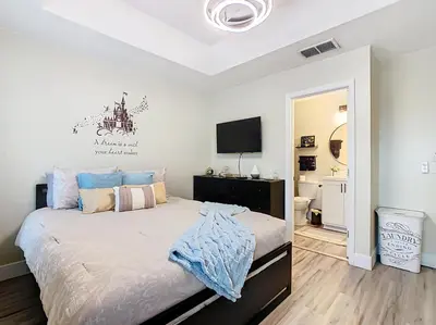 a bedroom with a bed and a flat screen tv at 3BR Family-Friendly Town Home Near Disney in Orlando