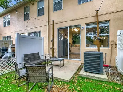 a patio with two chairs and a table in front of a building at 3BR Family-Friendly Town Home Near Disney in Orlando