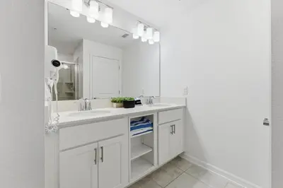 a white bathroom with a sink and a mirror at 207 Storey Lake 6 Guests 2 BDRS near clubhose in Kissimmee